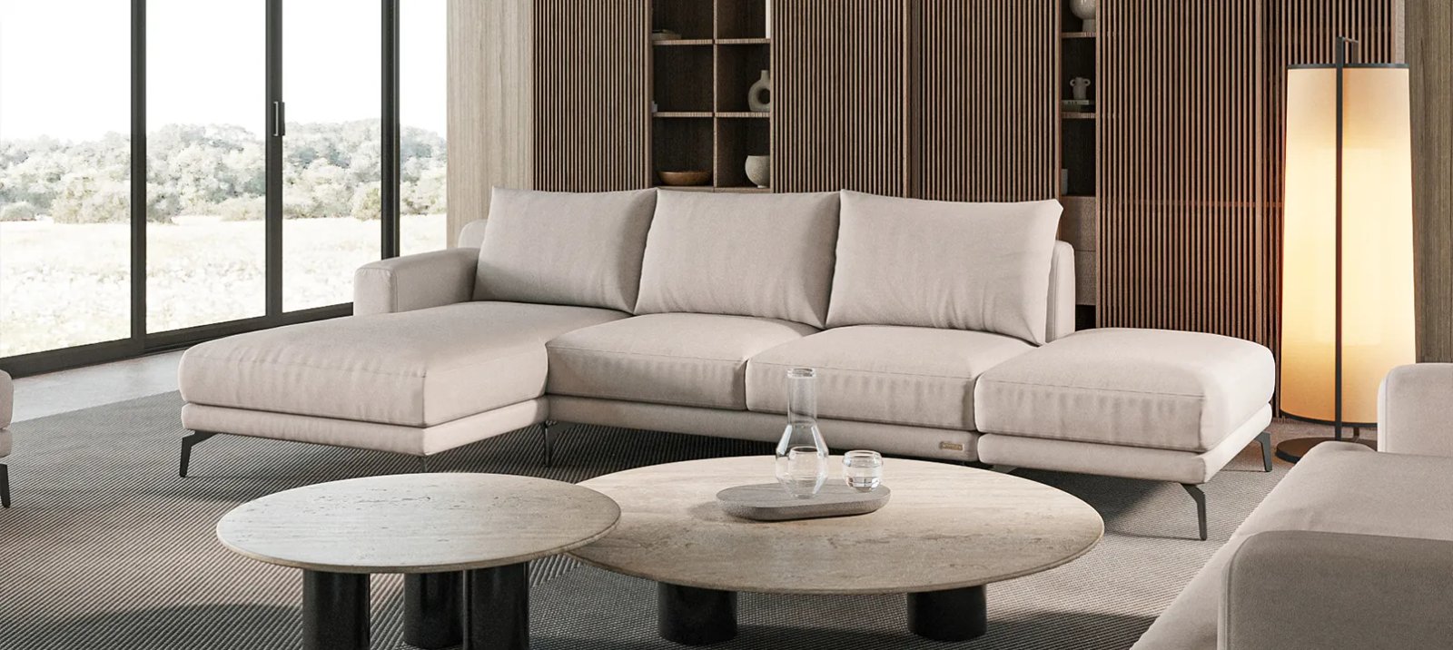 Sydney sofa iš šono su žemu korpusu gilia sėdyne ir plonomis tamsiomis kojelėmis.