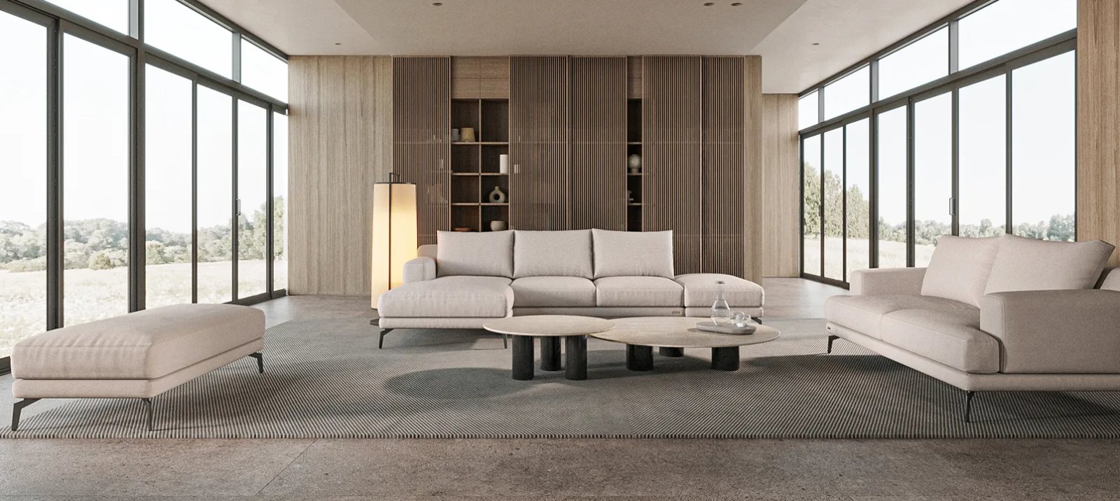 Pilka Sydney sofa su plačiomis sėdynėmis minkštomis pagalvėmis ir žemais porankiais.