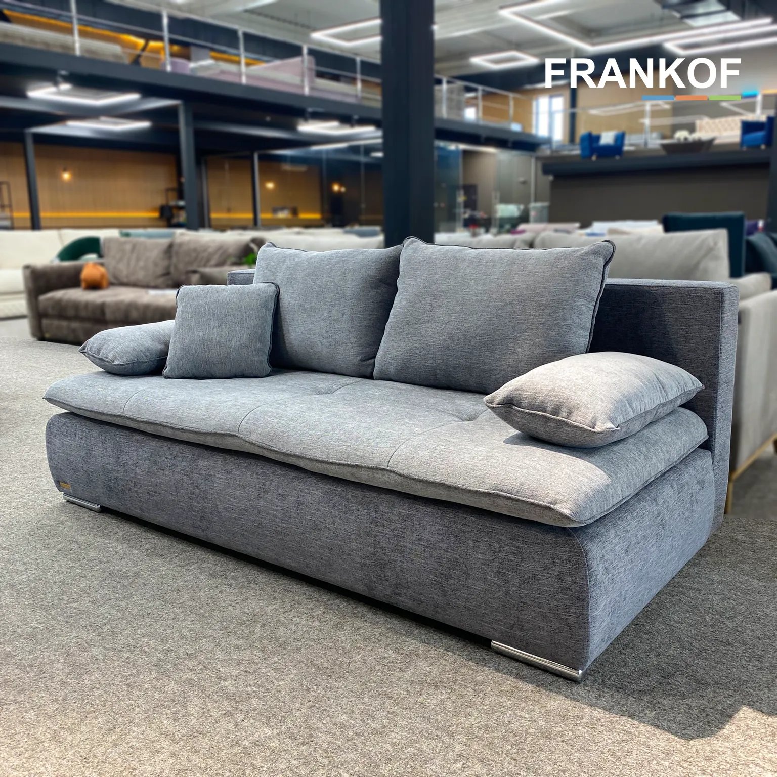 Warsaw sofa iš priekio su minkštomis pagalvėmis ir plačiais žemais porankiais.