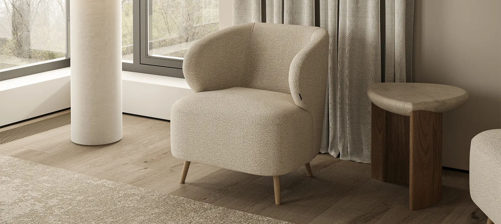 Smėlinis Noto fotelis iš šono prie žemo apvalaus staliuko moderniame neutraliame interjere.