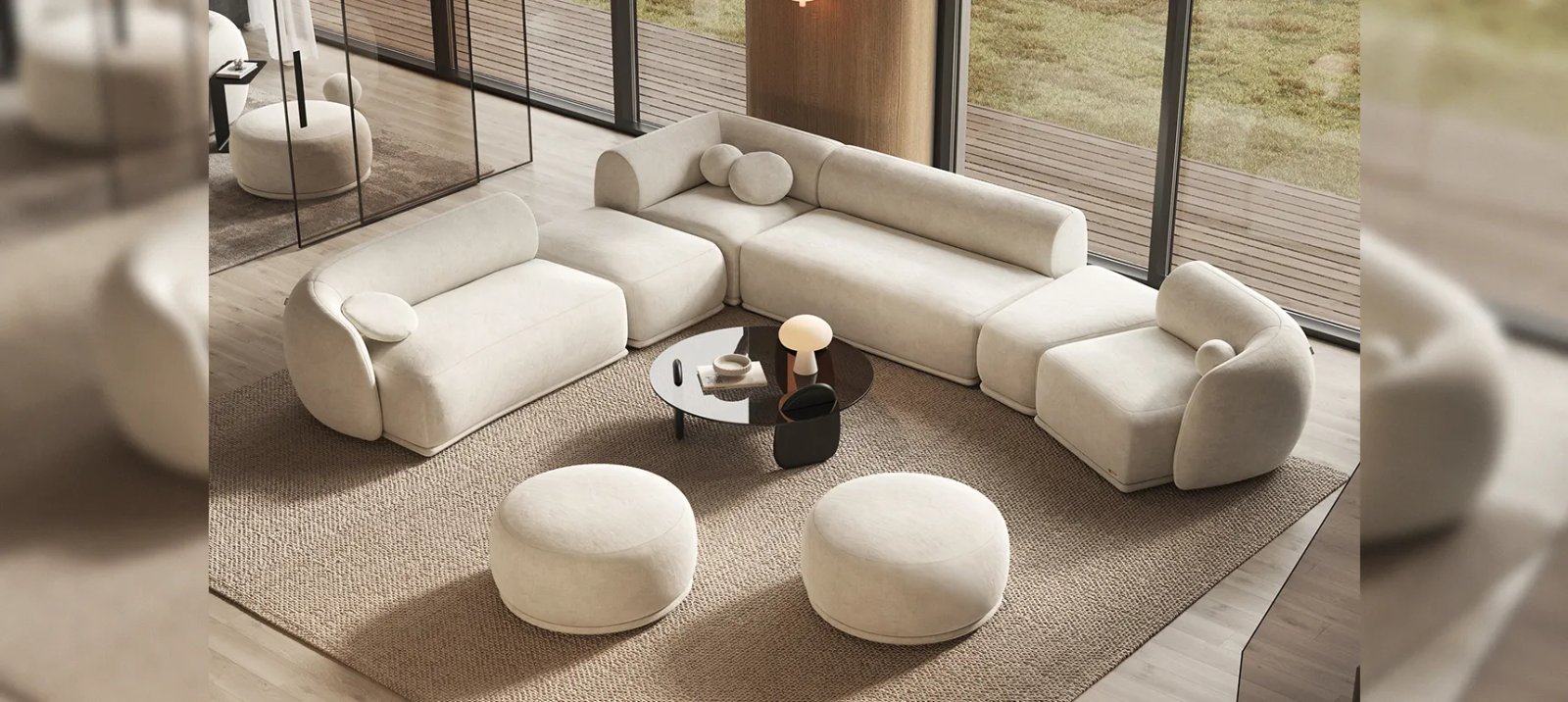 Kreminė Otis modulinė sofa iš lenktų dalių aplink apvalų staliuką. Priekyje du apvalinti pufai.
