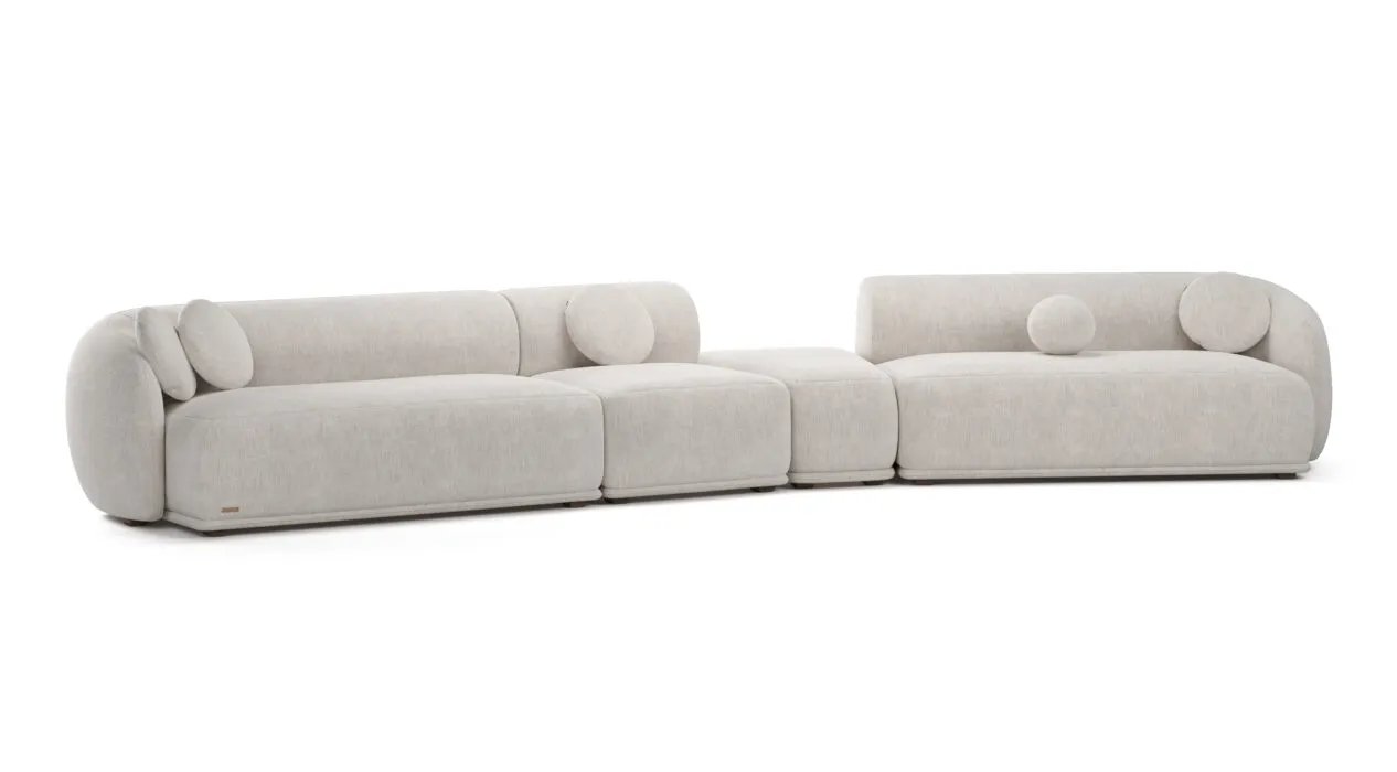 Kreminė Otis modulinė sofa su dviem plačiomis sėdimomis dalimis ir žemais apgaubiančiais atlošais.