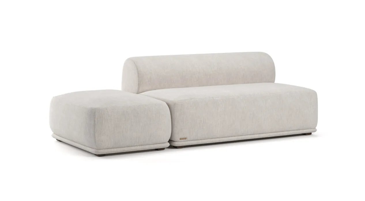 Kreminė Otis sofa su plačia kairine gulimąja dalimi ir žemu lenktu atlošu.