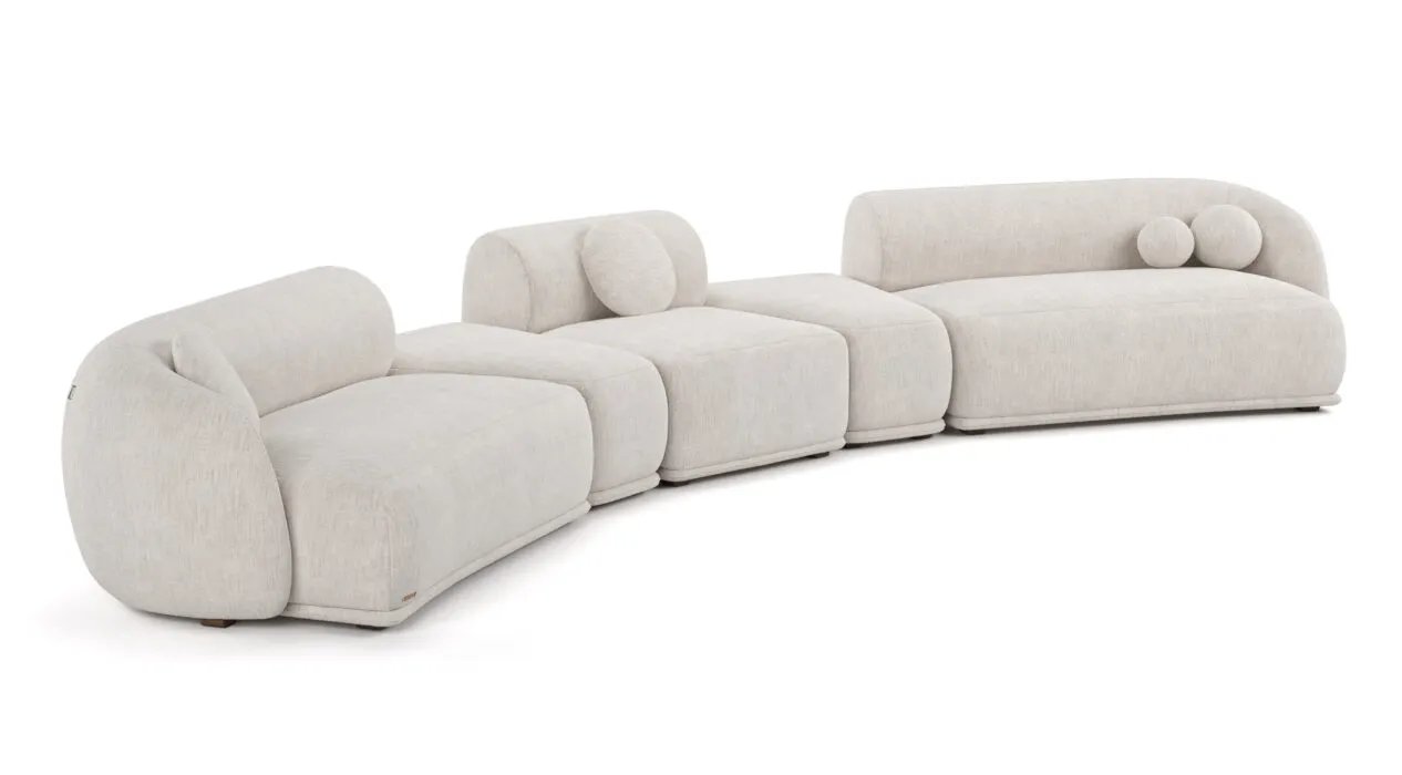 Ilga kreminė Otis modulinė sofa iš kelių lenktų segmentų su žemais atlošais ir apvaliomis pagalvėlėmis.