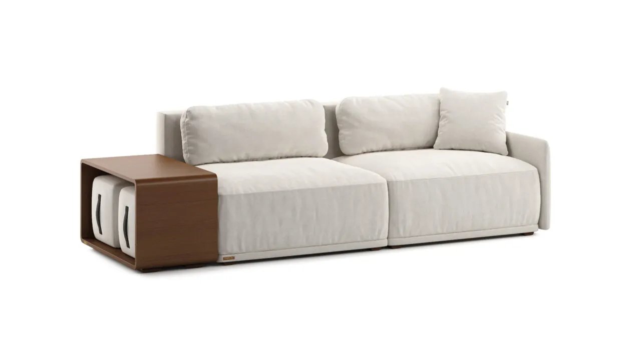 Kreminė Cruse sofa su laisvomis nugaros pagalvėmis. Rudo šoninio staliuko nišoje laikomi du šviesūs pufai.