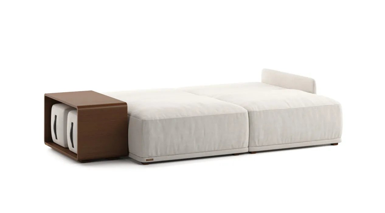 Išskleista kreminė Cruse sofa lova su dviem plačiomis miego dalimis. Rudoje šoninėje nišoje laikomi du pufai.