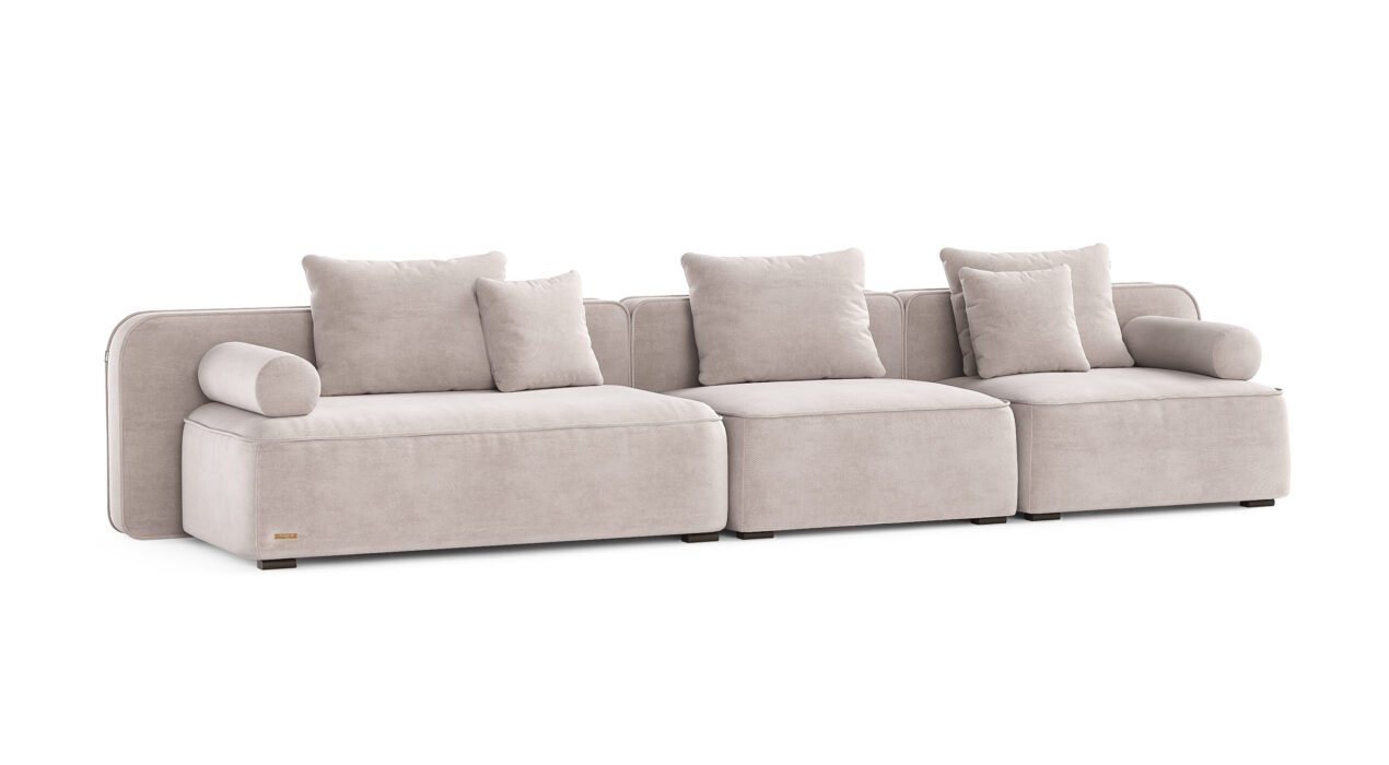Norman kampinė sofa su giliomis sėdimosiomis dalimis ir minkštu tekstiliniu apmušalu.